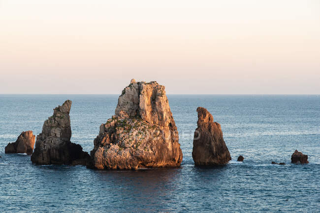 Pintoresco paisaje de rocas en el mar tranquilo y horizonte en el crepúsculo en la Costa Brava - foto de stock