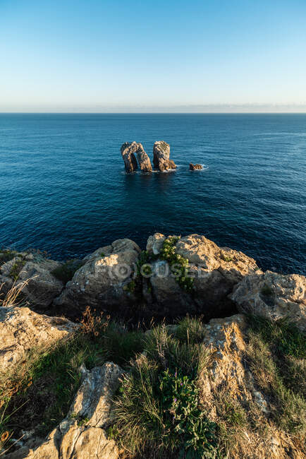 Paysage pittoresque de rochers dans la mer paisible et les toits de la Costa Brava — Photo de stock
