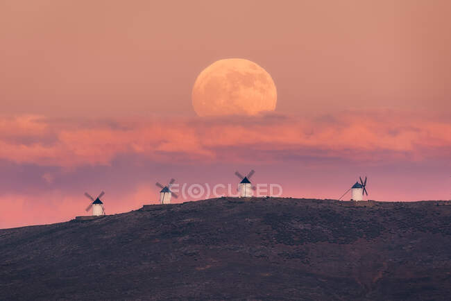 Amazing scenery of majestic full Moon over valley with windmills in sundown — Stock Photo