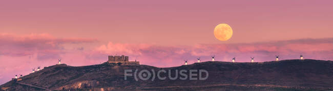 De baixo paisagem pitoresca de fortaleza envelhecida abandonada no topo da montanha iluminada pela lua cheia à noite em Toledo — Fotografia de Stock