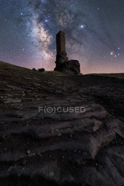From below unrecognizable tourist exploring ruined medieval castle under starry sky with Milky Way at night — Stock Photo