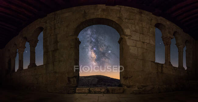 Vista occhio di pesce della Via Lattea galassia attraverso l'ingresso arco del vecchio castello in rovina di notte — Foto stock
