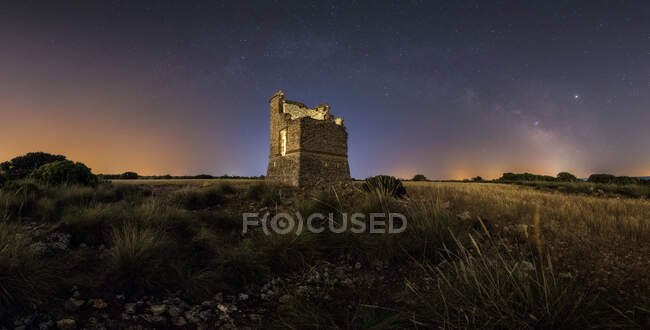 From below picturesque landscape of ancient ruined castle on meadow under Milky Way on starry sky at night — Stock Photo
