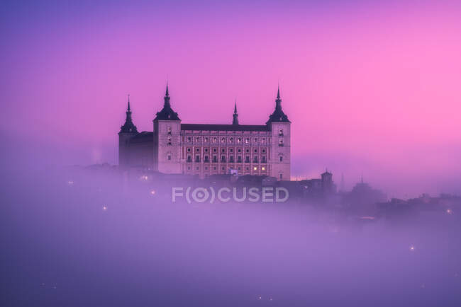 D'en haut magnifique paysage de château médiéval construit au-dessus de la ville au lever du soleil coloré brumeux — Photo de stock