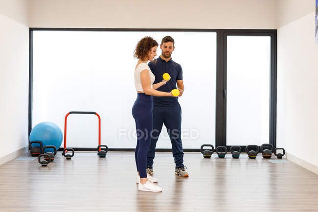 Sporty signora pratica esercizi di resistenza con istruttore personale — Foto stock
