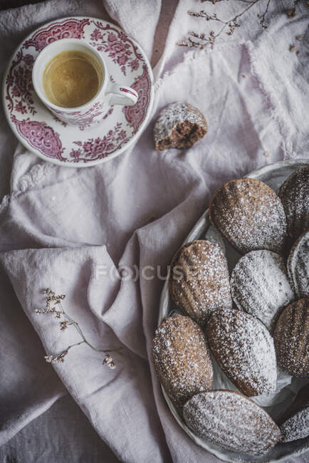 Зверху зверху апетитне солодке печиво, яке подається з порошкоподібним порошком на столі з чашкою чаю — стокове фото