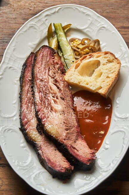 Vista superior de fatias de carne com pedaço de pão e ketchup na placa na mesa — Fotografia de Stock