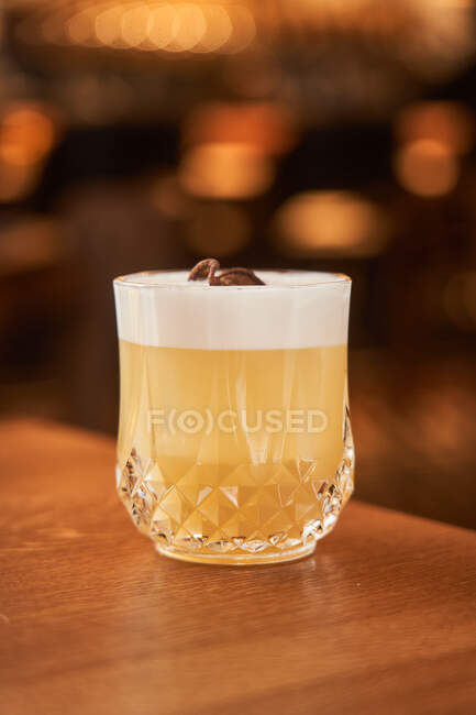 Glass of classic alcohol cocktail Whiskey Sour with lemon juice and egg white placed on wooden counter — Stock Photo