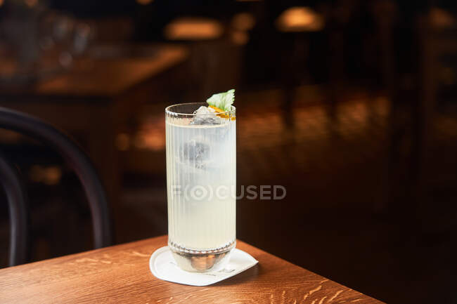 Vodka and tonic alcohol cocktail in highball glass decorated with ice and mint leaves on dark background — Stock Photo