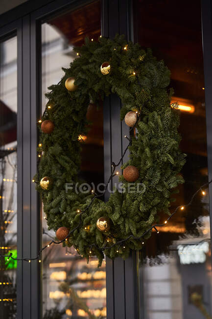 Fachada de café com decorações coloridas de ramos coníferas e árvore de Natal com guirlandas à luz do dia — Fotografia de Stock