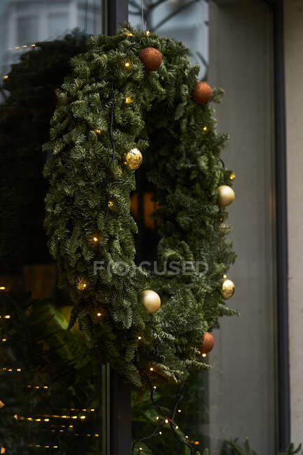 Fassade des Cafés mit bunten Dekorationen aus Nadelzweigen und Weihnachtsbaum mit Girlanden im Tageslicht — Stockfoto