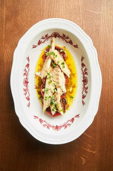 Von oben köstliche Thunfischstücke mit Tomatenscheiben auf Teller auf Tisch — Stockfoto