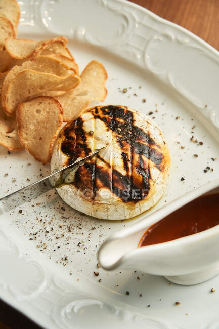 De cima delicioso hambúrguer de frango grelhado com batatas fritas crocantes assadas e molho de churrasco na placa na mesa — Fotografia de Stock