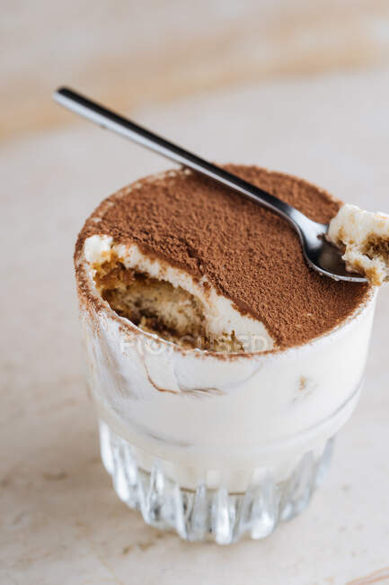 From above delicious traditional coffee flavored dessert tiramisu served in glass cup on table — Stock Photo