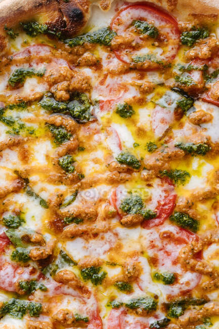 Сверху сочная запеченная пицца с сыром и зеленым песто — стоковое фото