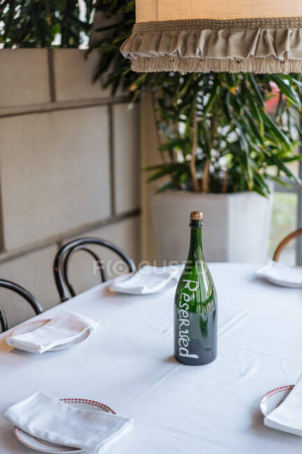 Lugar requintado caro com mesa e cadeiras cobertas com lâmpada quente e garrafa de álcool no restaurante — Fotografia de Stock