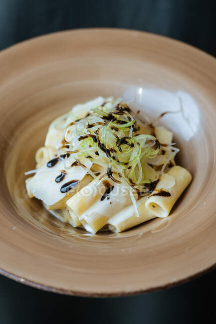 Сверху вкусная макароны с сыром и соевым соусом в тарелке на столе — стоковое фото