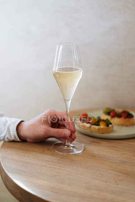 Crop client holding glass and waiting while crop bartender pouring alcohol in restaurant — Stock Photo