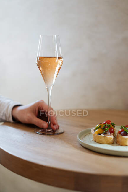 Crop client holding glass and waiting while crop bartender pouring alcohol in restaurant — Stock Photo