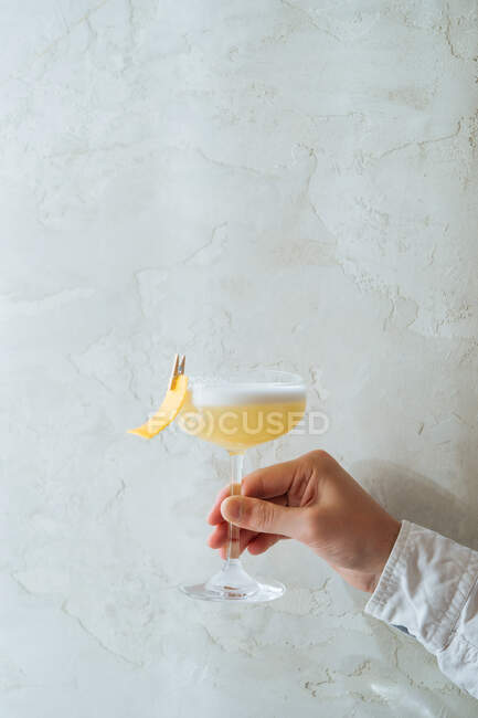 Cropped unrecognizable person holding fresh appetizing cocktail in glass festively decorated with clothespin — Stock Photo