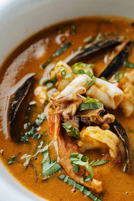 From above closeup ragout with fish mussels boiled small octopus and herbs on plate in restaurant — Stock Photo