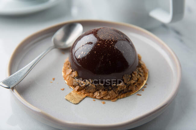 Haute Cuisine Süßwaren Produkt aus cremigem Mousse in Schokolade mit Müsli auf Teller mit Löffel dekoriert — Stockfoto