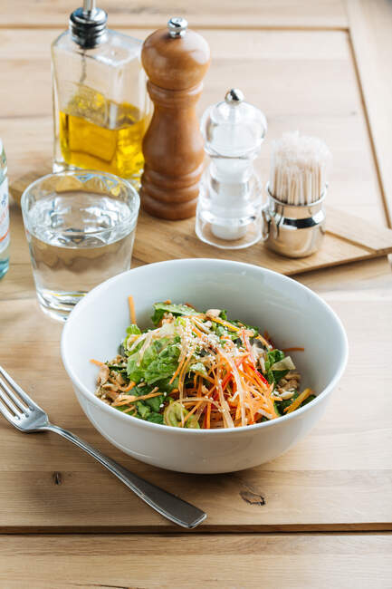 D'en haut salade savoureuse saine avec du soja germé et des graines dans un bol sur une table en bois — Photo de stock