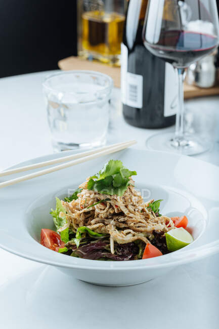 Von oben frischer Salat aus Tomaten, Limetten und Salat, serviert mit Fleischstücken und Petersilie im Restaurant — Stockfoto