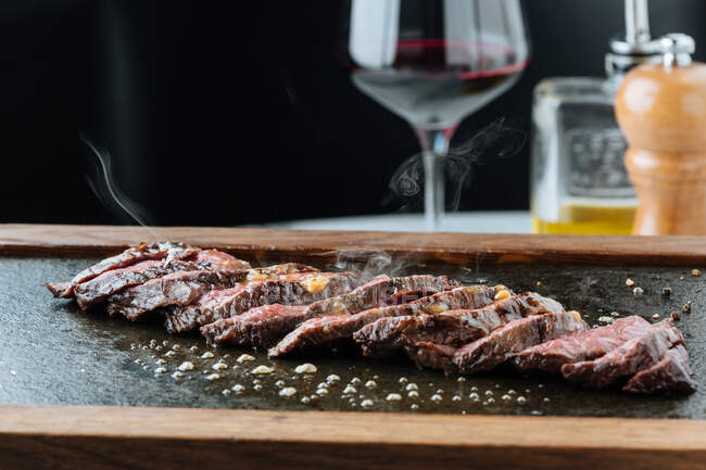 Top view of medium rare slices steak on table with fork and knife in restaurant — Stock Photo