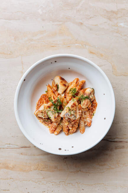 From above of delicious pasta served with cheese pieces of roasted meat and herbs in restaurant — Stock Photo
