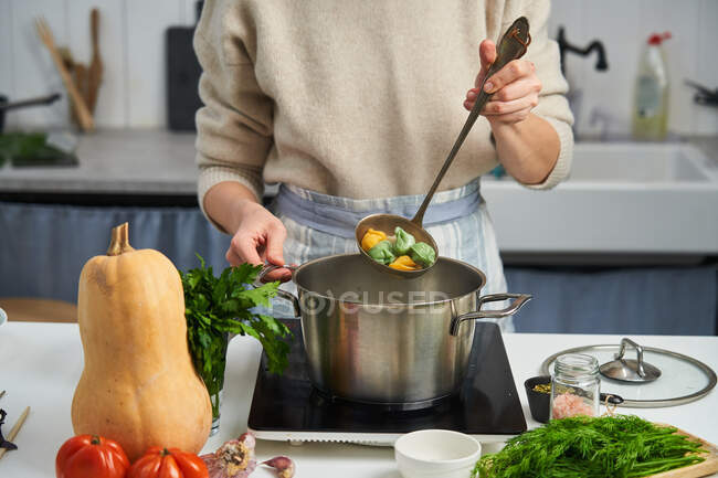 Chef femenino anónimo que comienza a cocinar albóndigas con masa colorida - foto de stock