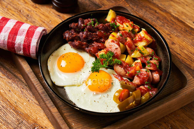 Fried eggs with vegetables in pan — Stock Photo