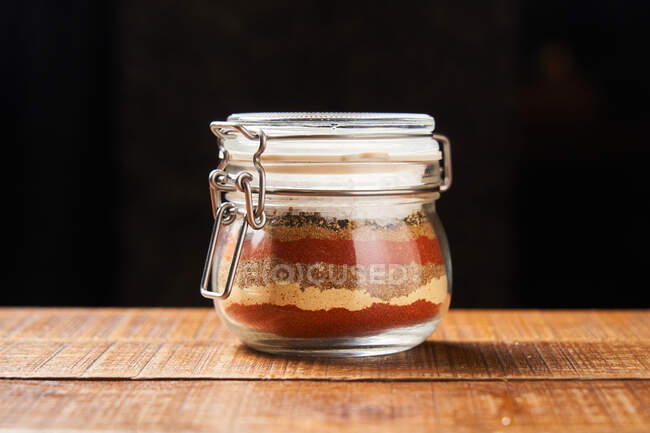 Layers of colorful spices in jar — Stock Photo