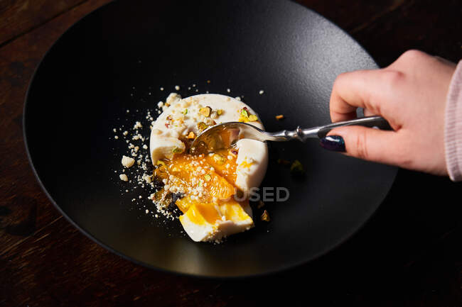 Mulher anônima comendo sobremesa elegante com colher — Fotografia de Stock