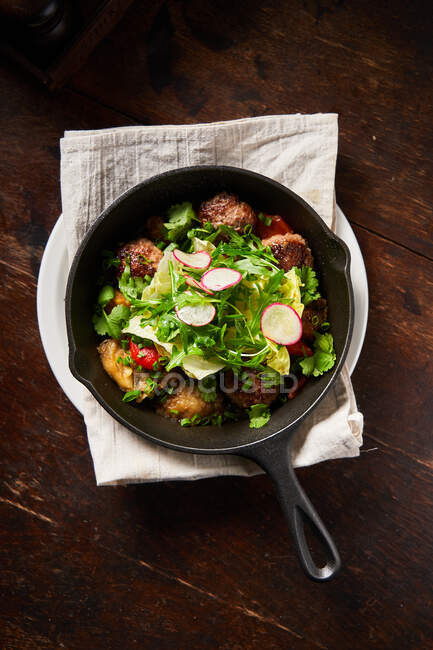 Жареные фрикадельки и салат в кастрюле — стоковое фото