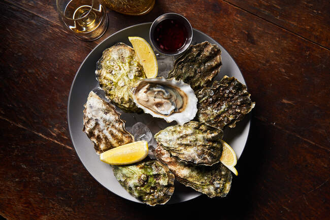 Fresh oysters with lemons in restaurant — Stock Photo