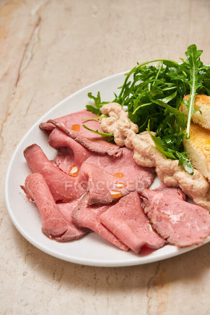Tasty meat with bread and arugula — Stock Photo