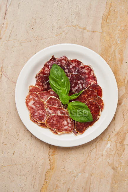 Pieces of dried meat with basil — Stock Photo