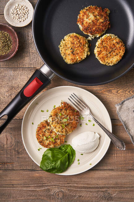 Tasty cutlets in pan and plate — Stock Photo