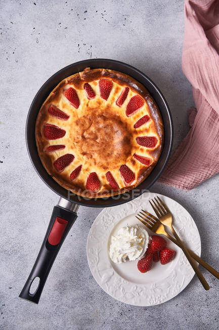 Cutting baked pie with strawberry in pan on table — Stock Photo