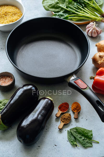 Fresh ingredients around empty frying pan — Stock Photo