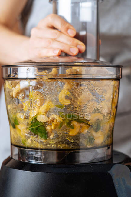 Anonymous person mixing ingredients in blender — Stock Photo