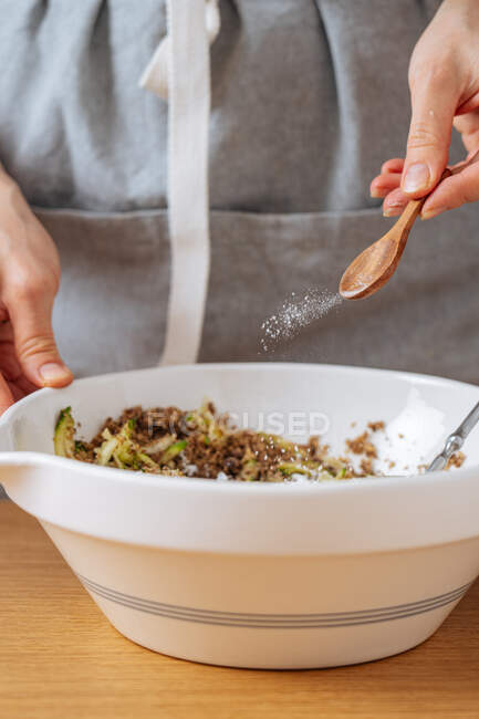 Mulher preparando comida e adicionando sal — Fotografia de Stock