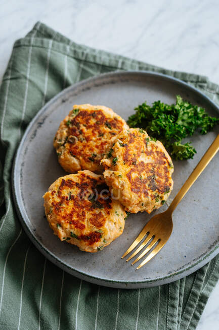 Deliciosas costeletas grelhadas saudáveis feitas de peixe e legumes servidos em placa de metal com garfo e decorados com brócolis — Fotografia de Stock