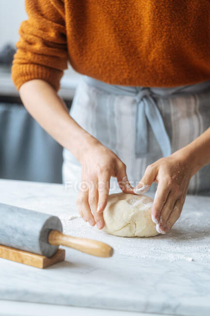 Cozinhe a massa de farinha que amassa com a mão na mesa — Fotografia de Stock
