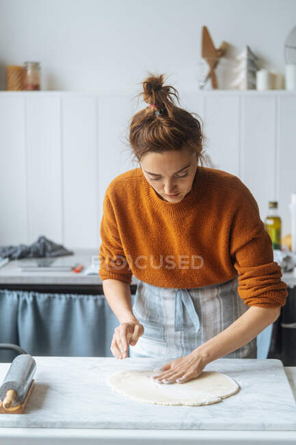 Cook kneading dough with hand on table — Stock Photo
