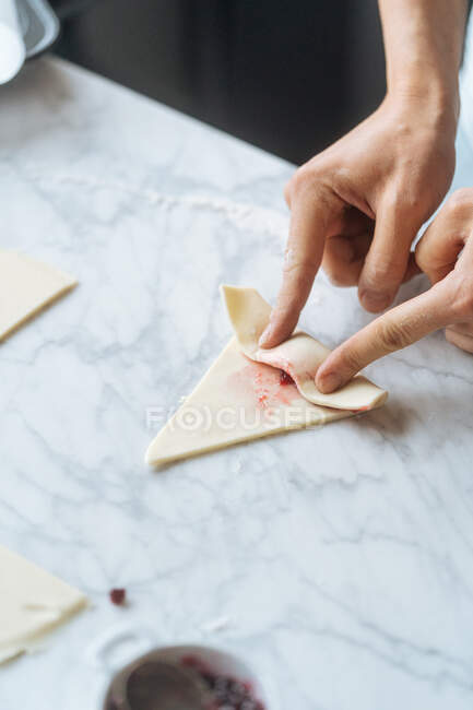 Cook twisting dough into croissant on table — Stock Photo