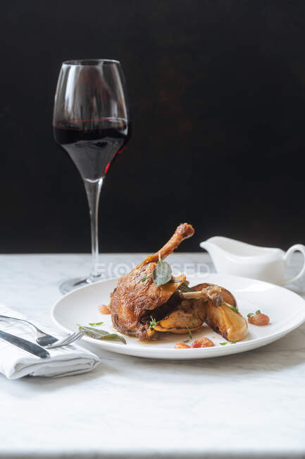 Roasted quail and glass of red wine — Stock Photo