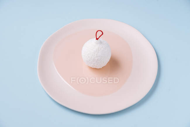 Bauble shaped coconut dessert on plate — Stock Photo