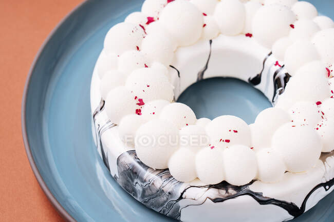 De arriba delicioso pastel de anillo con hielo en forma de burbuja colocado en el plato - foto de stock